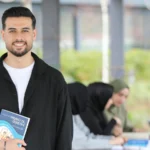 University student using an iPhone to take notes during a lecture – best note-taking app for iPhone